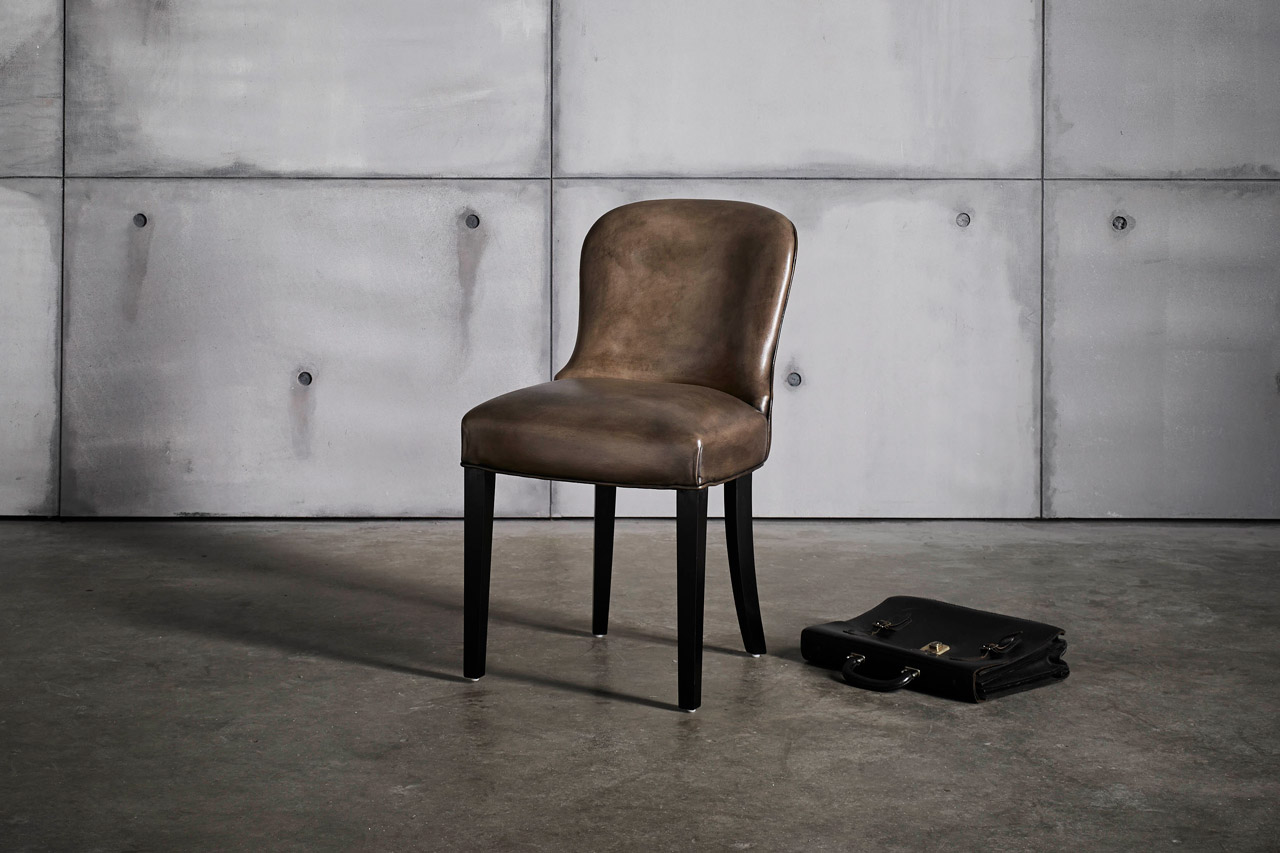 Diner genuine leather dining chair with a gently curved backrest form reminiscent of a sculptural spoon
