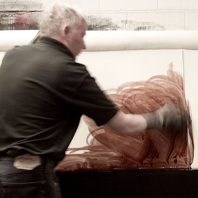 Homme teignant à la main un canapé Chesterfield en cuir